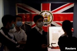 香港中学生走过香港历史博物馆内的一面港英旗帜 (2020年20月16日)