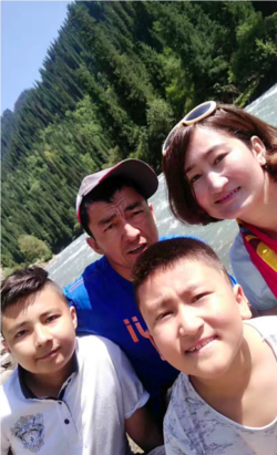 在这张日期不明的照片中,热纳古尔·艾尼与孩子和丈夫合影。(照片由坎比努尔·艾尼提供)