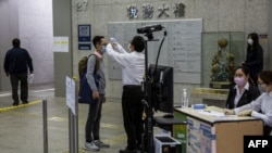 戴着口罩的复工人员走入香港政府税务大楼接受体温检测。(2020年3月2日)