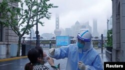 上海一名医护人员在对当地居民进行核酸检测(2022年4月26日)