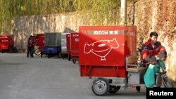 资料照:京东快递人员在北京市海淀区递送快件。(2013年11月20日)