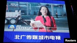 北京一家商场外的巨型电子屏幕正在播放华为高管孟晚舟从加拿大抵达深圳的报道。(2021年9月26日)