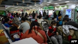 中国面临冬季呼吸道疾病激增。家长和孩子在北京一家医院的门诊候诊(2023年11月23日)