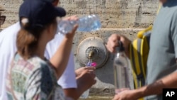 人们在梵蒂冈圣彼得广场的喷泉前排队。(资料照片:2024年8月11日)