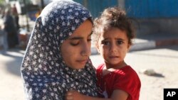 Người dân ở khu Shajaiyeh, thành phố Gaza, bỏ nhà cửa chạy trốn sau khi Israel thả tờ rơi cảnh báo người dân rời khỏi khu vực, 16/7/2014.