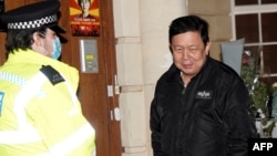 Myanmar's Ambassador to the United Kingdom, Kyaw Zwar Minn, stands with police officers locked outside the Myanmar Embassy in London on April 7, 2021. - Myanmar's ambassador in Britain on Wednesday said a Yangon miltary-linked figure had "occupied" the em