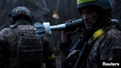 在乌克兰顿涅茨克州前线,在俄军持续进攻之际,乌军士兵准备发射迫击炮弹。(2022年12月31日)