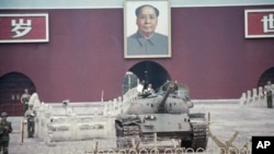 资料照:示威运动被镇压后停在天安门毛泽东像下的解放军坦克。(1989年6月11日)