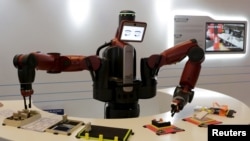 在中国大连举行的世界经济论坛会议上,机器人表演拿名片(2015年9月9日)