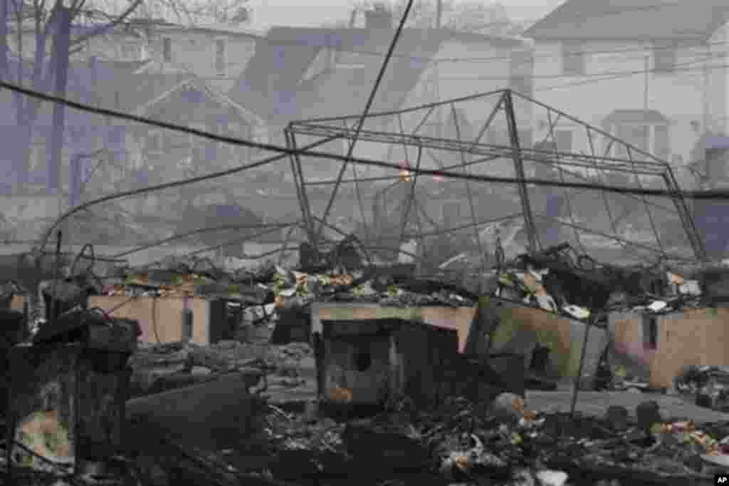 2012年10月30日,被火烧毁的民宅余烬未熄。10月29日夜,纽约市皇后区一处社区因超级风暴桑迪来袭先遭水淹后又起火,有80到100所房屋被毁。