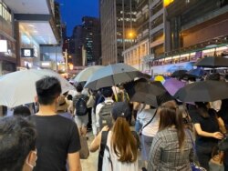 参与中环流水式游行人士占据马路,高举雨伞,导致交通受阻,但是没有捣路及冲击警方,游行过程大致和平 (美国之音/汤惠芸)