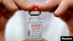 美国康涅狄格州的一名药剂师展示一瓶莫德纳疫苗。(2021年2月17日)