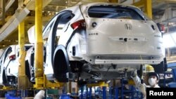 戴口罩的工人在武汉的东风集团本田汽车公司的一条生产线上工作。(2020年3月16日)