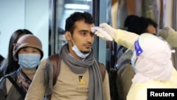 抵达利雅得的旅客在哈利德国王国际机场接受沙特卫生官员检测体温。(2020年1月29日)