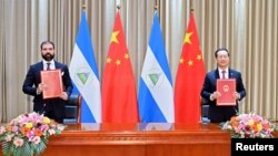 中国外交部副部长马朝旭(右)和尼加拉瓜代表在天津签署联合公报。(2021年12月10日)