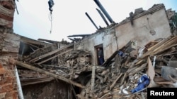 在乌克兰哈尔科夫州库皮扬斯克,当地居民和救援人员站在被俄罗斯导弹摧毁的当地博物馆的废墟上。(2023年4月25日)