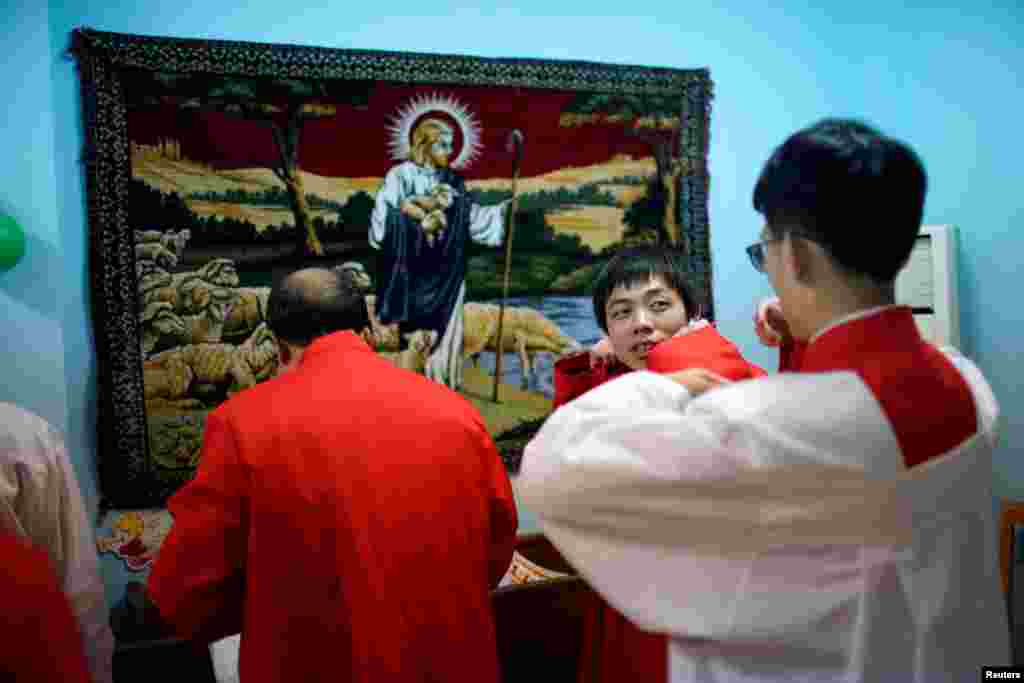 2017年12月24日,中国上海一个天主教教堂的耶稣像前面,信徒准备参加圣诞节游行。