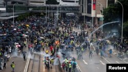 在香港湾仔地区的一次反政府示威期间,抗议者逃避警方释放的催泪弹。(2019年10月6日)