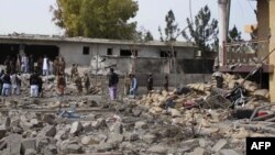 Afghan security forces inspect the site of a bomb attack in Lashkar Gah, the capital of Helmand province, March 18, 2015. 