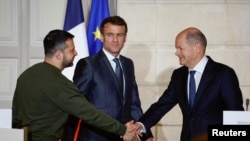 Президент України Володимир Зеленський і канцлер Німеччини Олаф Шольц потискають руки під час спільної заяви з президентом Франції Еммануелем Макроном у Єлисейському палаці в Парижі, Франція, 8 лютого 2023 року. REUTERS/Sarah Meyssonnier/Pool