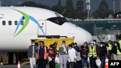 被美国驱逐出境的危地马拉移民抵达危地马拉空军基地后走上跑道。 2024年总计有超过 61,000危地马拉无证移民被美国驱逐出境。(法新社:2024年12月27日)