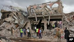 索马里安全部队和民众在星期六在首都摩加迪沙爆炸袭击的地点附近搜索遇难者遗体。(2017年10月15日)