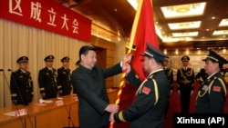 中国国家主席习近平(左前)在北京举行的中国人民解放军战区成立大会上向五大战区授予军旗。(2016年2月1日)