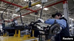 资料照片:在北京一家由北汽集团出资的北京电动车工厂,一名员工在生产电子汽车的装配线上工作。(2016年1月18日)