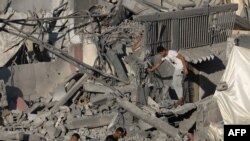 Người Palestine đi trên đống đổ nát của những tòa nhà bị phá hủy trong cuộc pháo kích của Israel vào trại tị nạn Nuseirat, ở trung tâm Dải Gaza vào ngày 30/10/2023, trong bối cảnh các trận chiến đang diễn ra giữa Israel và nhóm Hamas của Palestine.