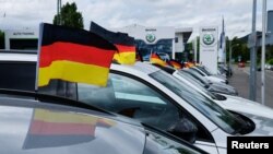 德国波恩附近一家车行的停车场上待售汽车插着德国国旗。(2024年6月14日)