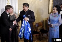 中国主席习近平和夫人在芬兰赫尔辛基参加国宴前,接受芬兰国家滑雪队赠送的运动衣(2017年4月5日)。习近平夫妇将从芬兰来到美国。