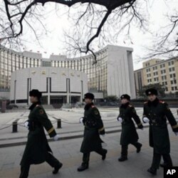 武警列队走过中国人民银行在北京的总部大楼(2011年2月9日)