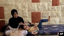 逃离以色列空袭后,一名流离失所的妇女和她的女儿坐在黎巴嫩贝鲁特南部小镇的联合国巴勒斯坦难民机构。(美联社:2024年10月4日)