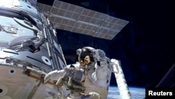 美宇航员在国际空间站外面行走的资料照片。