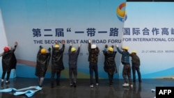 在第二届一带一路国际合作高峰论坛闭幕后,中国工人拆掉宣传板。(2019年4月27日)