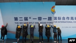 在第二届一带一路国际合作高峰论坛闭幕后,中国工人拆掉宣传板。(2019年4月27日)