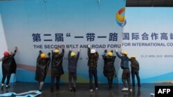 在第二届一带一路国际合作高峰论坛闭幕后,中国工人拆掉宣传板。(2019年4月27日)