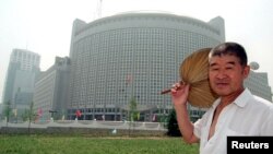 一位北京人走过北京东北部的外交部大楼(1997年6月20日)