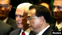 美国副总统彭斯与中国总理李克强在新加坡东盟峰会上交谈。(2018年11月15日)