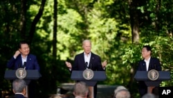星期五,美国总统拜登(中)在戴维营总统度假胜地与日本首相岸田文雄(右)和韩国总统尹锡悦举行联合新闻发布会。