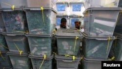 Afghan electoral workers sort ballot boxes at a counting center in Kabul, April 10, 2014.