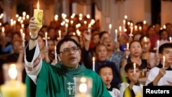 天主教神父邓友南在越南义安省安城教堂内为英国卡车尸体惨案的39名死者举行烛光祷告仪式,有大约500人参加。(2019年10月26日)