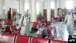 朝鲜官方朝中社2020年2月15日发布的照片显示,身穿防护服的人员在朝鲜一个没有说明的地点喷洒消毒剂以防范新冠病毒。