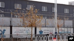 新疆和田市服装就业培训基地的外墙被两层铁丝网围住。(2018年12月5日)