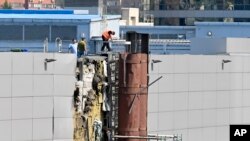 俄罗斯调查人员正在检查据报被无人机毁坏的一个展览馆。(2023年8月18日)