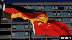 资料照:北京一家酒店前飘扬着德国和中国国旗。(2024年12月2日)
