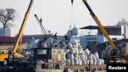 一只中国边境贸易的货船停泊在朝鲜新义州的岸边,正在卸货(资料照片)