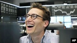 图为德国股指8月11日反弹,一名交易者喜笑颜开