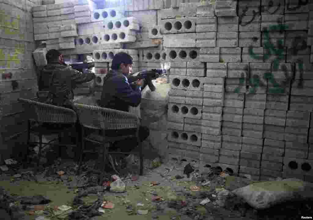 叙利亚自由军的战士12月24日在阿勒颇与忠于阿萨德总统的部队作战