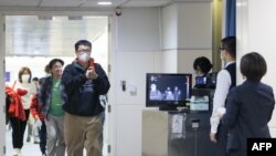 台湾疾病控制中心使用人体检测仪在桃园机场检测从武汉飞抵台北旅客的体温。(2020年1月13日)